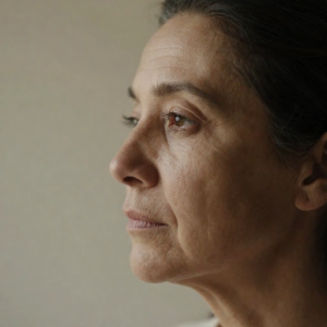 Mulher madura de perfil com sobrancelhas naturais e olhar suave em luz natural.