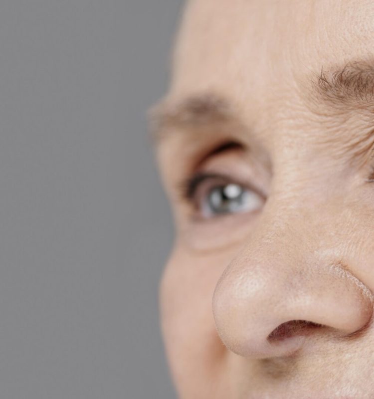 Close do olhar de uma mulher madura, com sobrancelhas naturais e fios suavemente transformados pelo tempo, transmitindo serenidade, permanência e delicadeza.