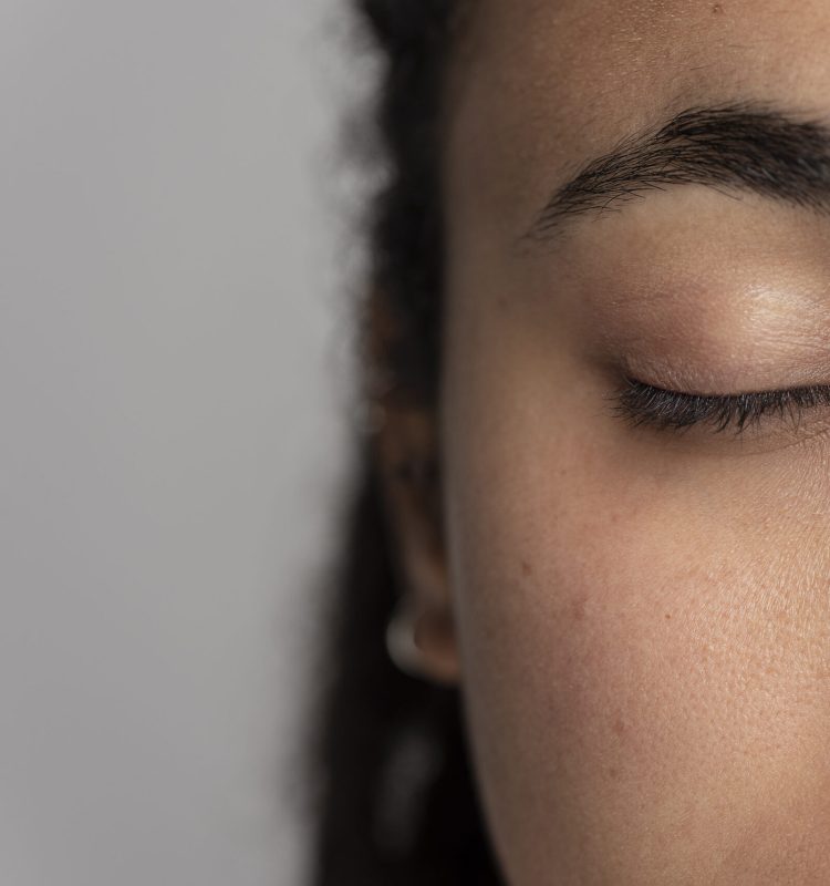 Sobrancelha natural em close, com olho fechado, revelando linhas suaves que sustentam o olhar e contribuem para a harmonia do rosto.