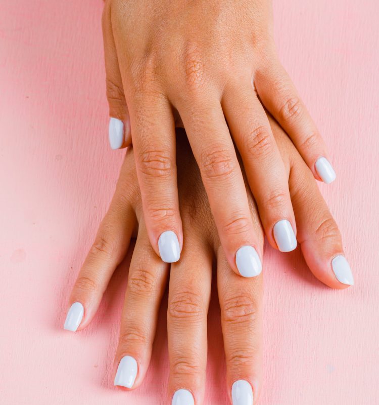 Unhas leitosas em tom claro e translúcido sobre fundo rosa suave, com acabamento delicado e aparência natural.