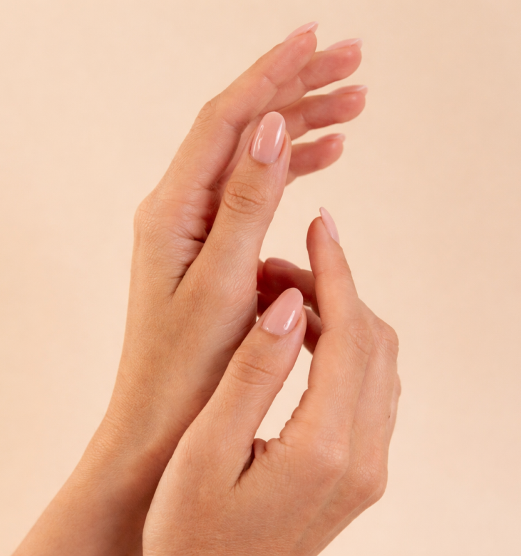 Mãos femininas com unhas naturais bem cuidadas em gesto suave, transmitindo delicadeza, autocuidado e beleza minimalista.